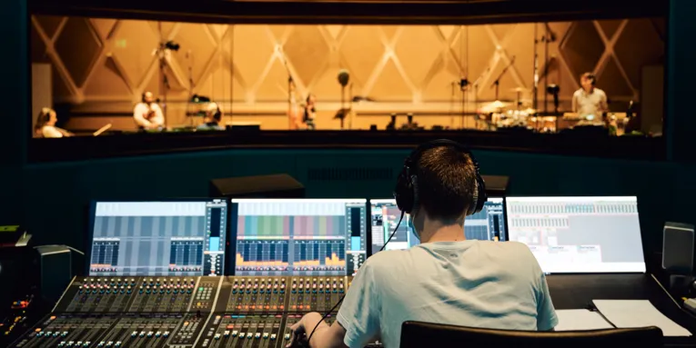 Ein Mann an einem großen Mischpult in einem Tonstudio